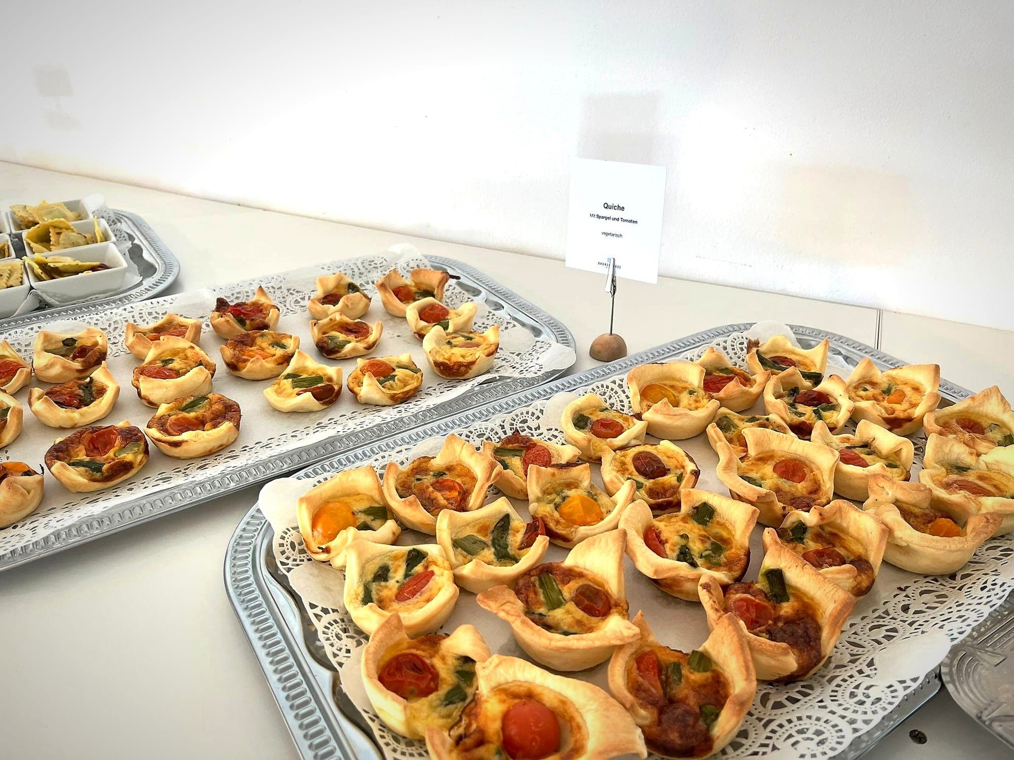 Flying Buffet von charlyfresh — Mini-Quiches mit Tomate und Spargel auf Silbertabletts